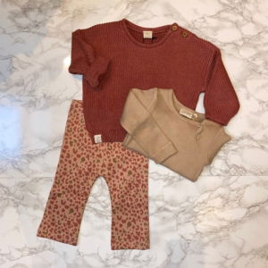 Flatlay van een schattige babyoutfit van Riffle Amsterdam en Petit Piao